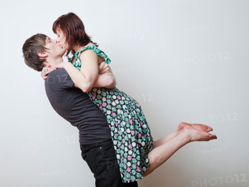 Happy young couple kissing in studio. Photo : Jessica Peterson