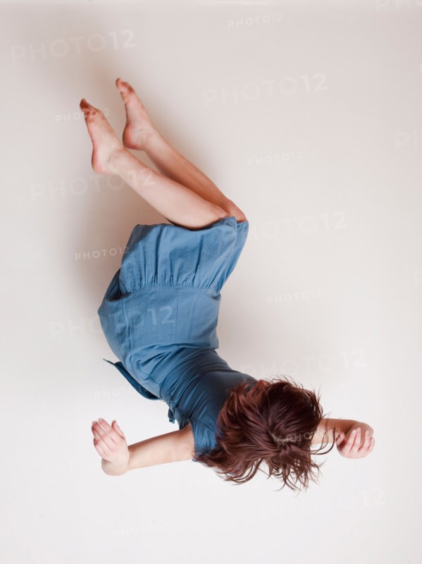 Young woman wearing blue dress falling upside down. Photo : Jessica Peterson