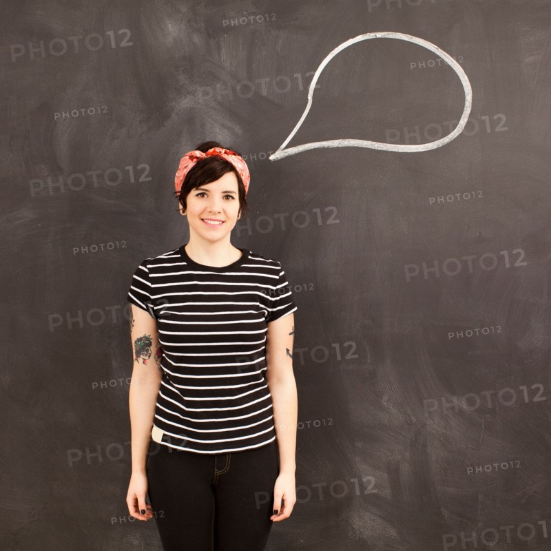 Portrait of young woman in front of blackboard. Photo : Jessica Peterson