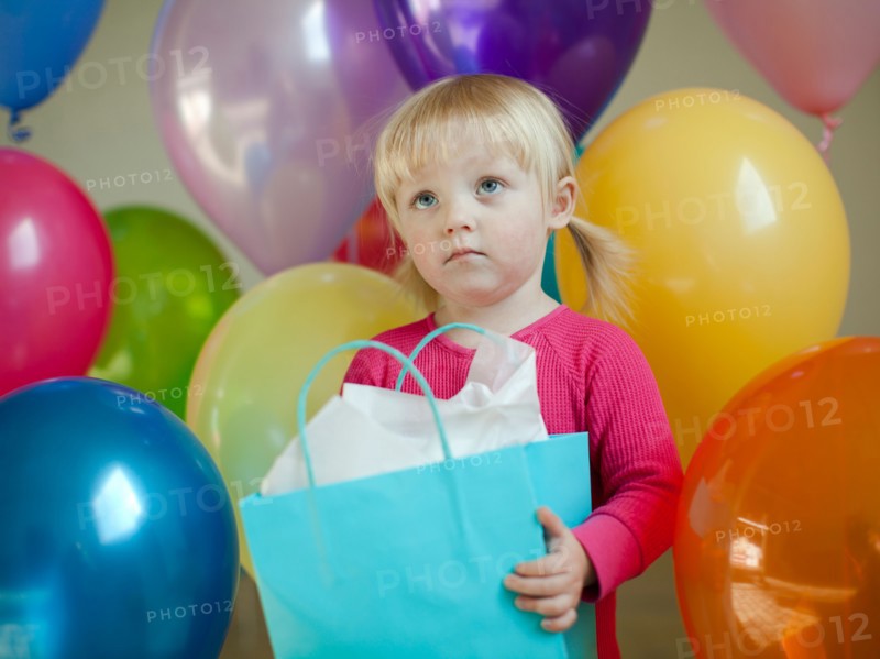 Portrait of baby girl (18-23 months) wit colorful balloons. Photo : Jessica Peterson