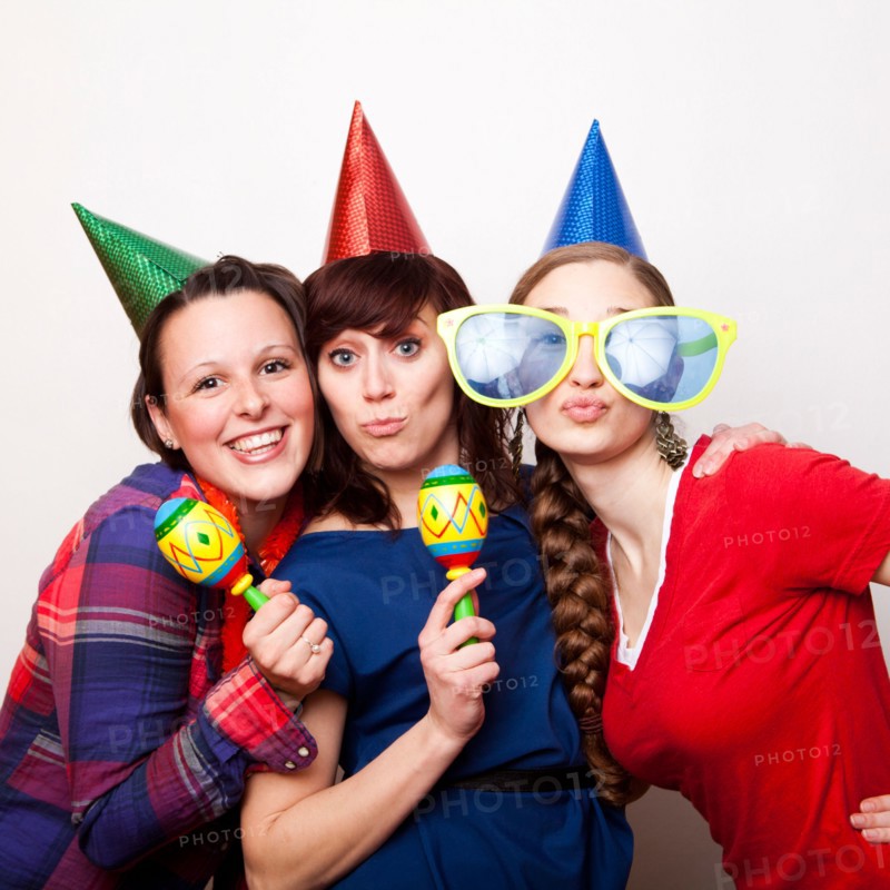 Studio Shot of young women dressed in party hat. Photo : Jessica Peterson