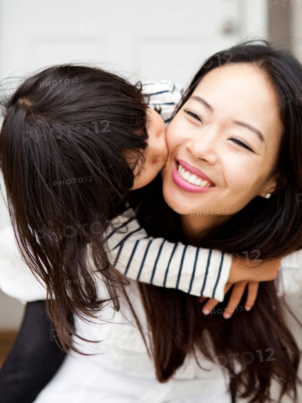 Smiling woman kissing by her daughter (4-5). Photo : Jessica Peterson