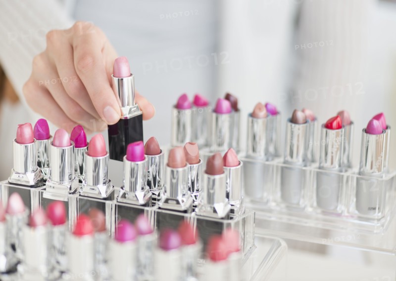 Hand of woman choosing lipstick.