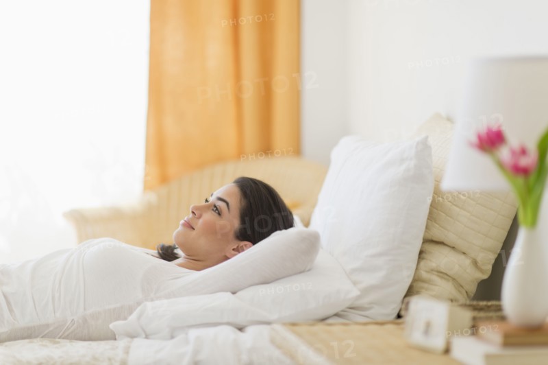 Young woman lying on bed.