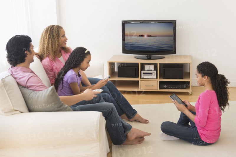 Parents with daughters (10-13) watching tv.