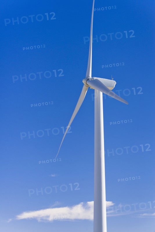 Wind turbine against blue sky.