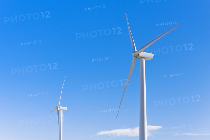 Wind turbines against blue sky.