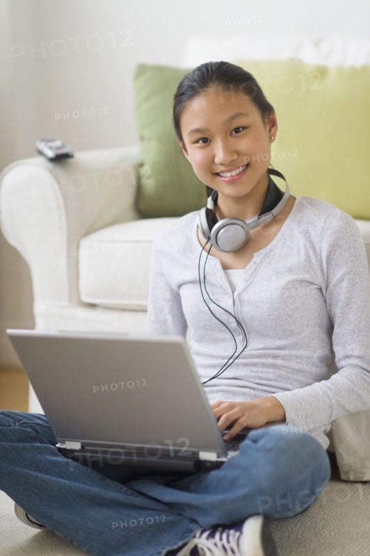 Portrait of girl (14-15) using laptop at home.