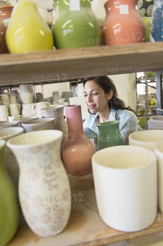 Female artist in pottery in studio.