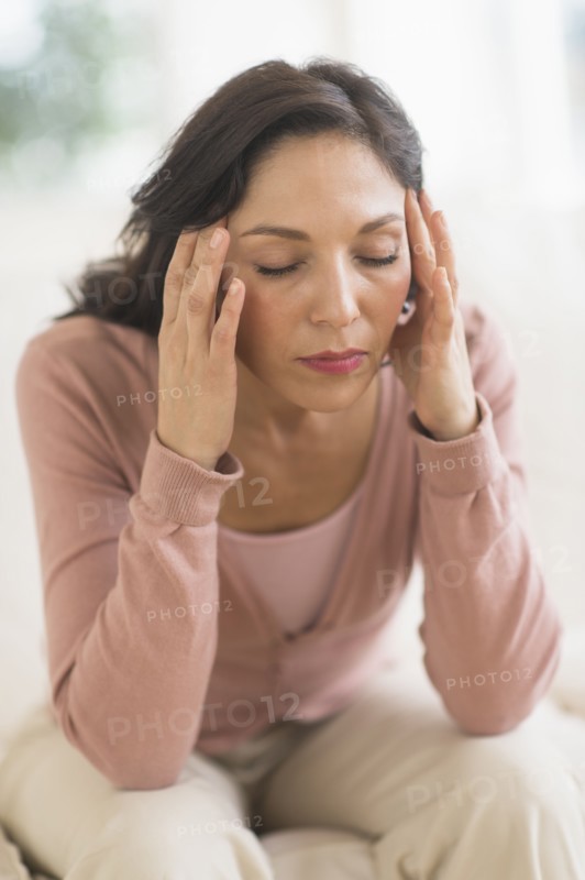 Woman sitting with head in hands.