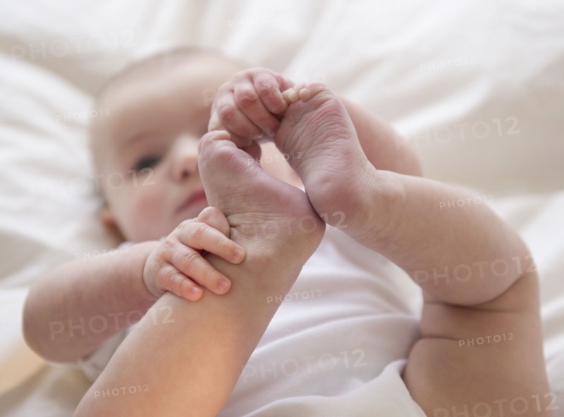 Baby boy (2-5) touching foot. 
Photo : Jamie Grill
