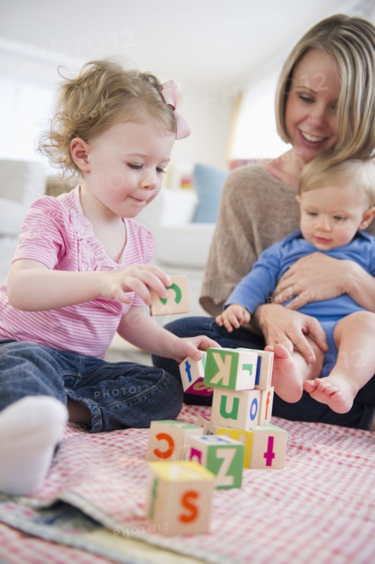 Mother playing with children (2-3, 6-11 months) at home. 
Photo: Jamie Grill