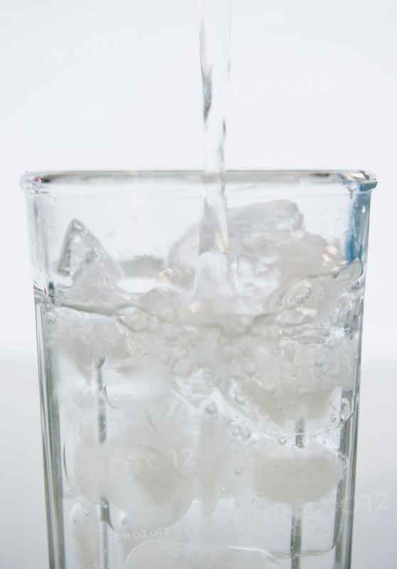 Water being poured into glass with ice cubes. 
Photo : Jamie Grill