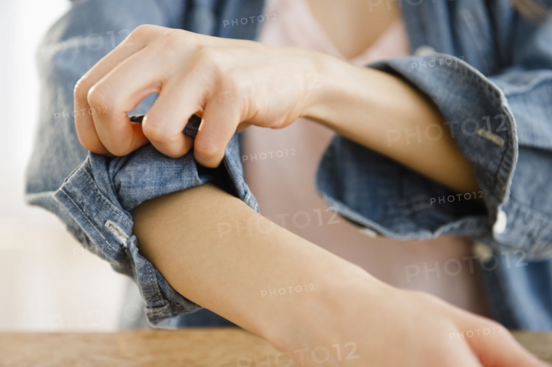 Woman rolling up sleeve. 
Photo: Jamie Grill