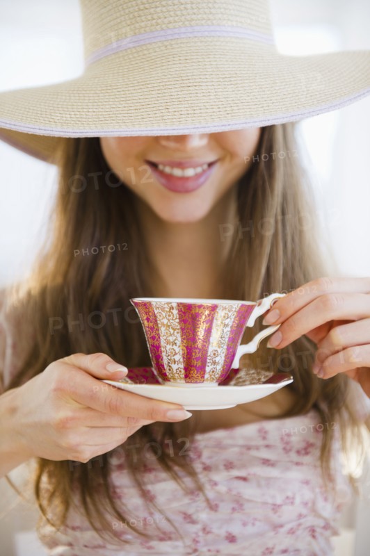 Woman wearing sun hat drinking tea. 
Photo: Jamie Grill