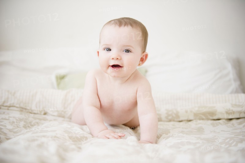 Baby girl (6-11 months) lying on bed. 
Photo : Jamie Grill