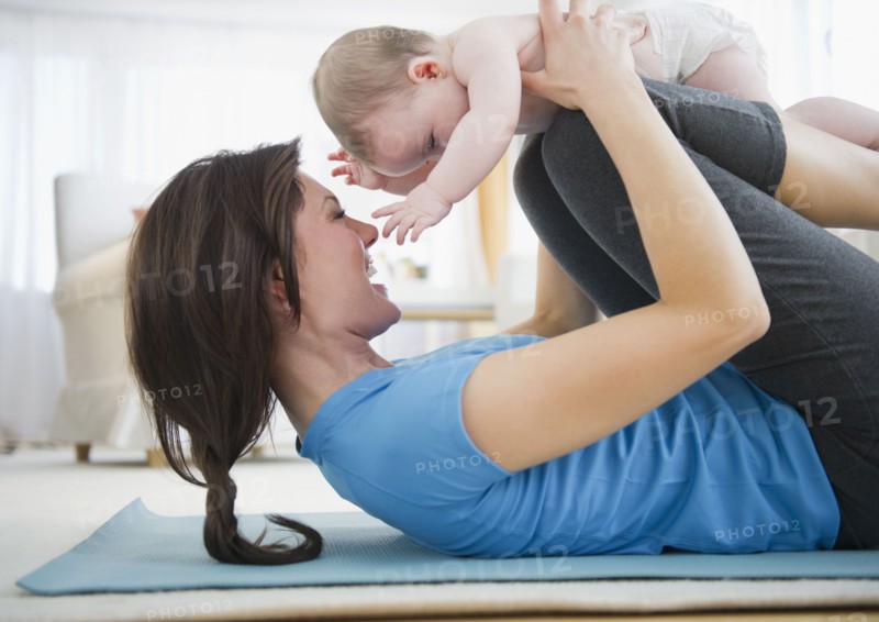 Mother with baby daughter (6-11 months) practicing yoga. 
Photo : Jamie Grill