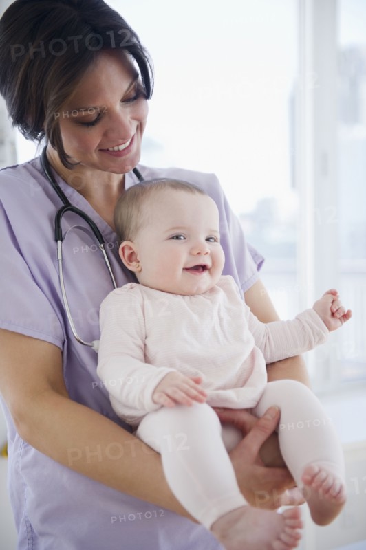 Female nurse with baby girl (6-11 months). 
Photo : Jamie Grill