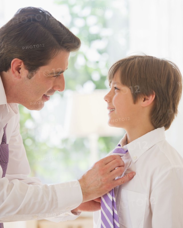 Father helping son (10-11 years) to tie tie. 
Photo: Daniel Grill