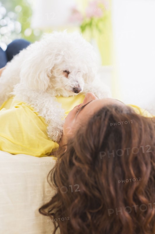 Woman lying on bed with her dog. 
Photo : Daniel Grill