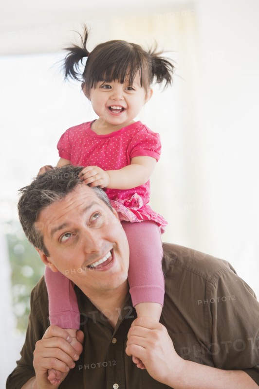Father carrying baby daughter (12-17 months) on shoulders. 
Photo : Daniel Grill