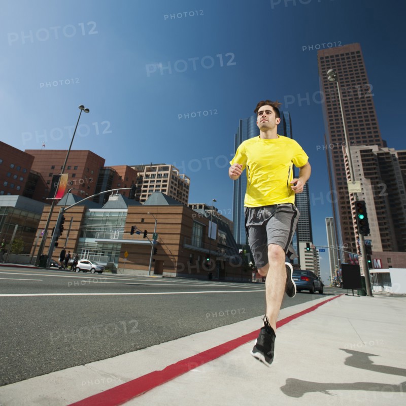USA, California, Los Angeles, Young man running on city street.