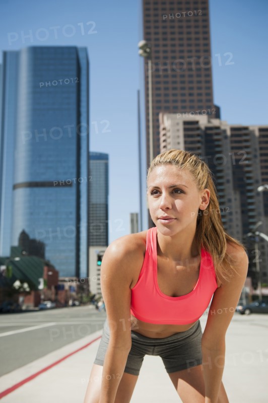 USA, California, Los Angeles, Young woman resting after running on city street. 
Photo: Erik Isakson