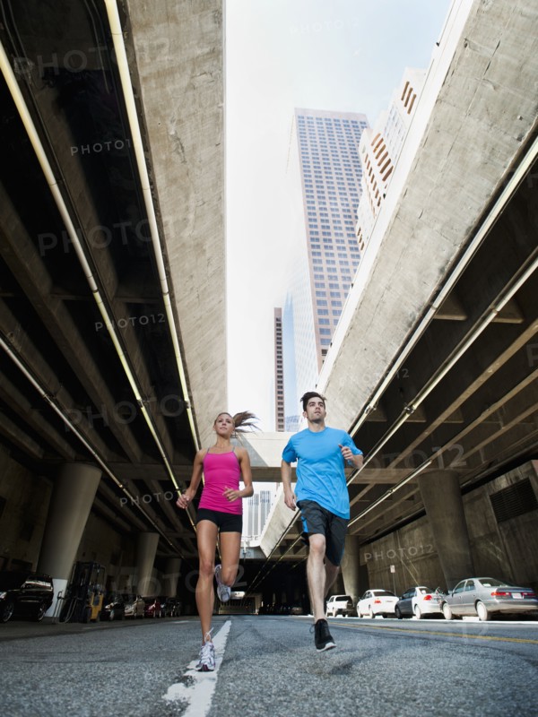 USA, California, Los Angeles, Young man and young woman running on city street. 
Photo: Erik Isakson