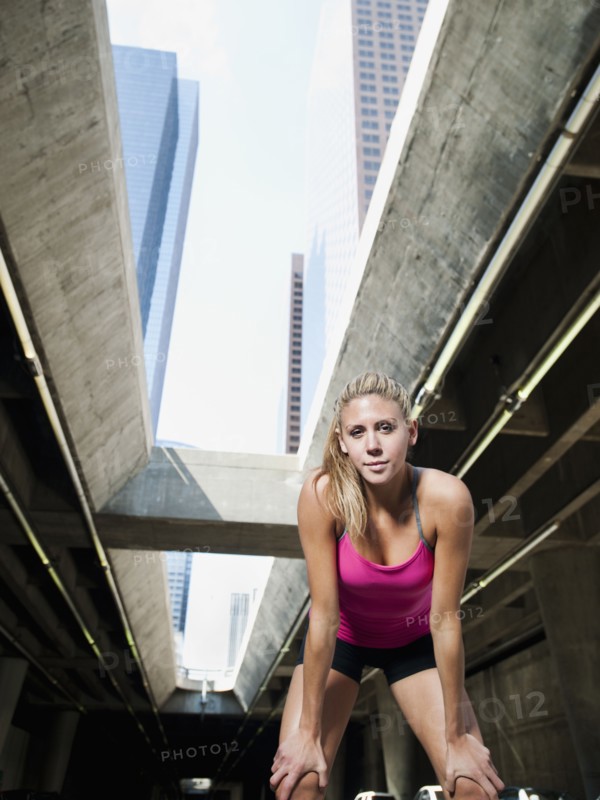 USA, California, Los Angeles, Young woman resting after running on city street.