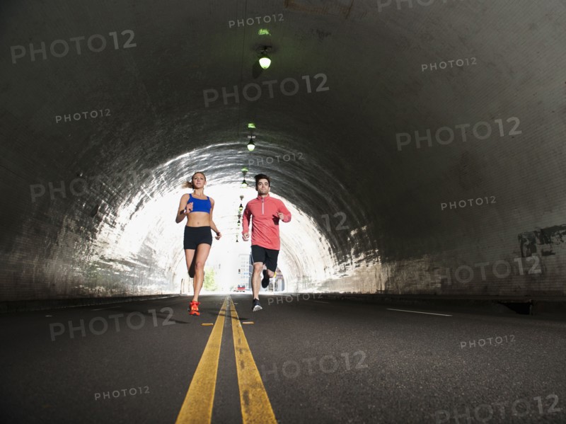 USA, California, Los Angeles, Young man and young woman running in tunnel. 
Photo: Erik Isakson
