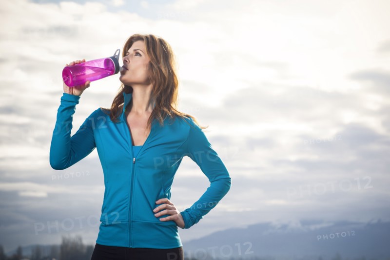 Woman drinking water after run. 
Photo : Take A Pix Media