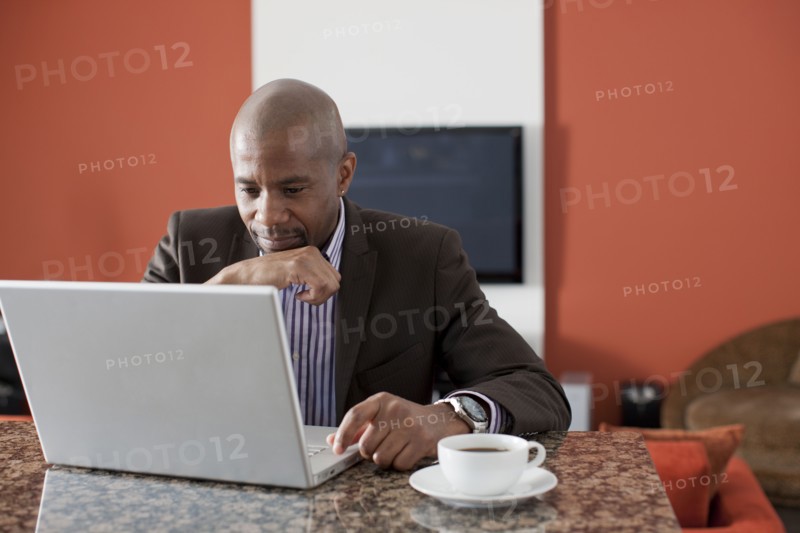 Man enjoying coffee while using laptop. 
Photo: Dan Bannister