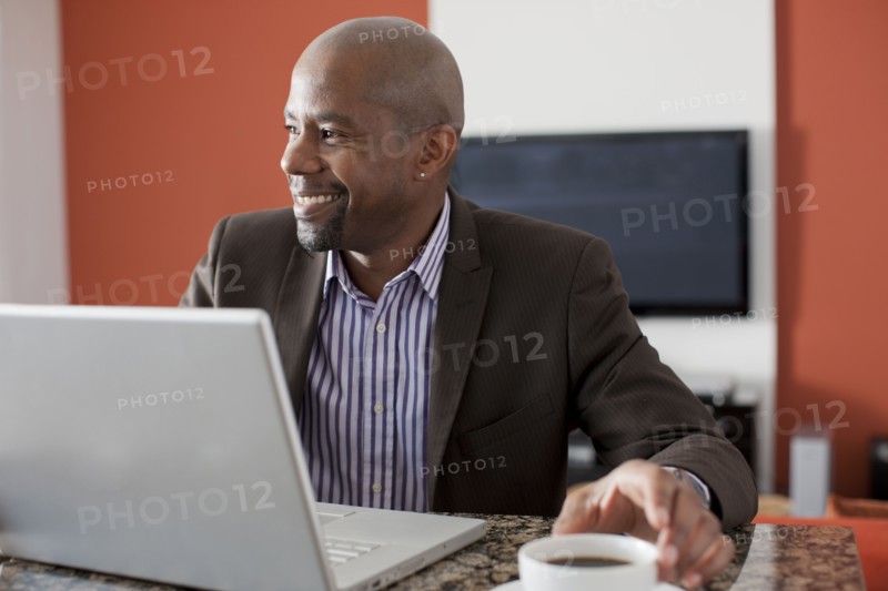 Man enjoying coffee while using laptop. 
Photo : Dan Bannister