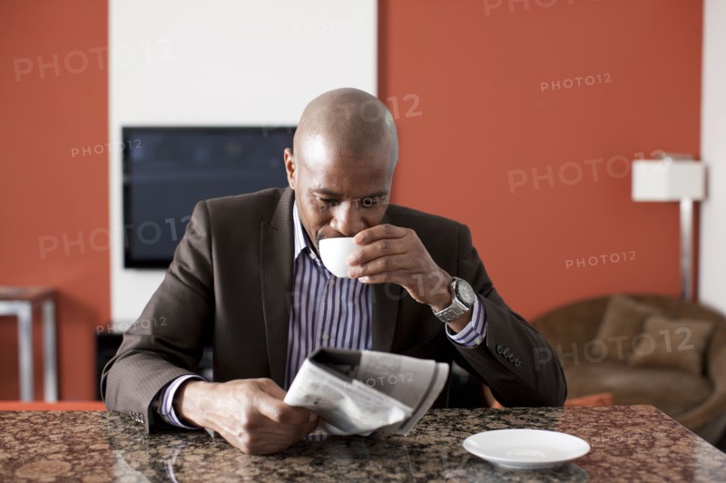 Man enjoying coffee and reading newspaper. 
Photo: Dan Bannister