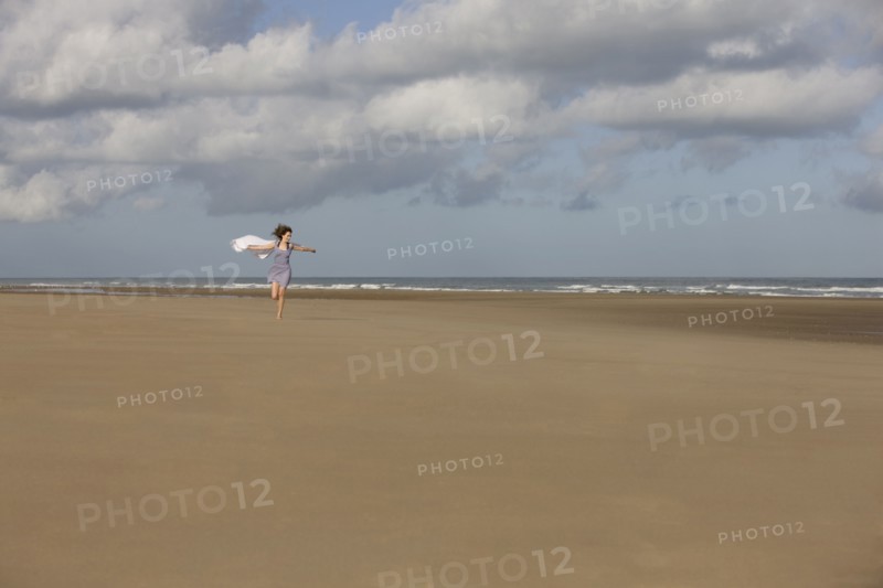 France, Pas-de-Calais, Escalles, Young woman strolling on empty beach. 
Photo : Jan Scherders