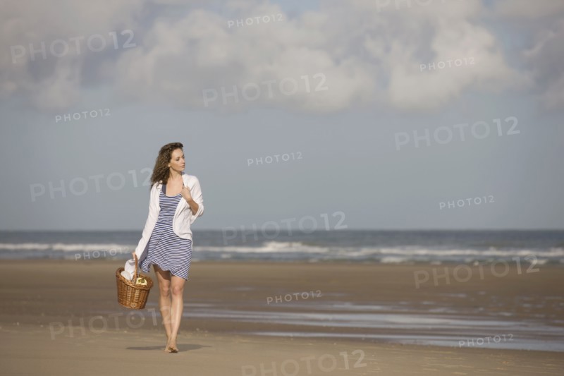 France, Pas-de-Calais, Escalles, Young woman strolling on empty beach. 
Photo: Jan Scherders