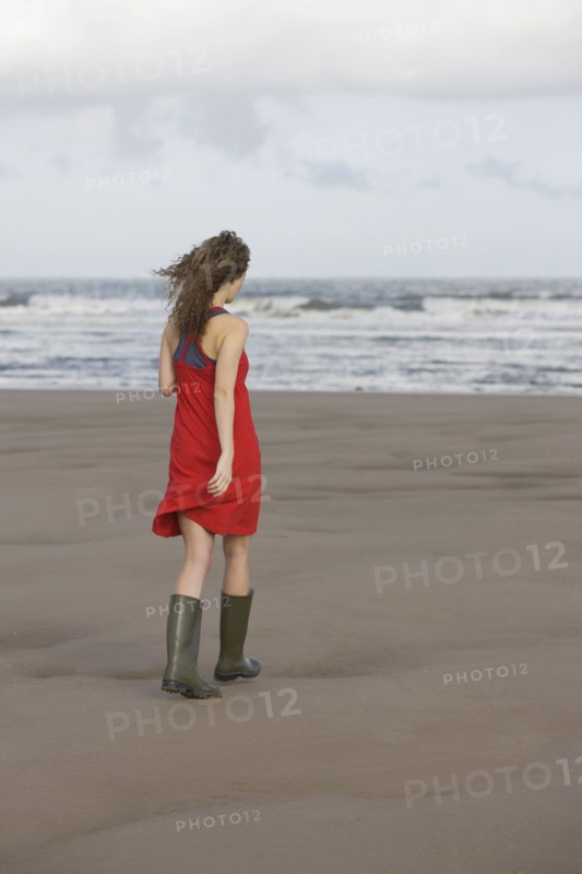 France, Pas-de-Calais, Escalles, Young woman strolling on empty beach. 
Photo: Jan Scherders