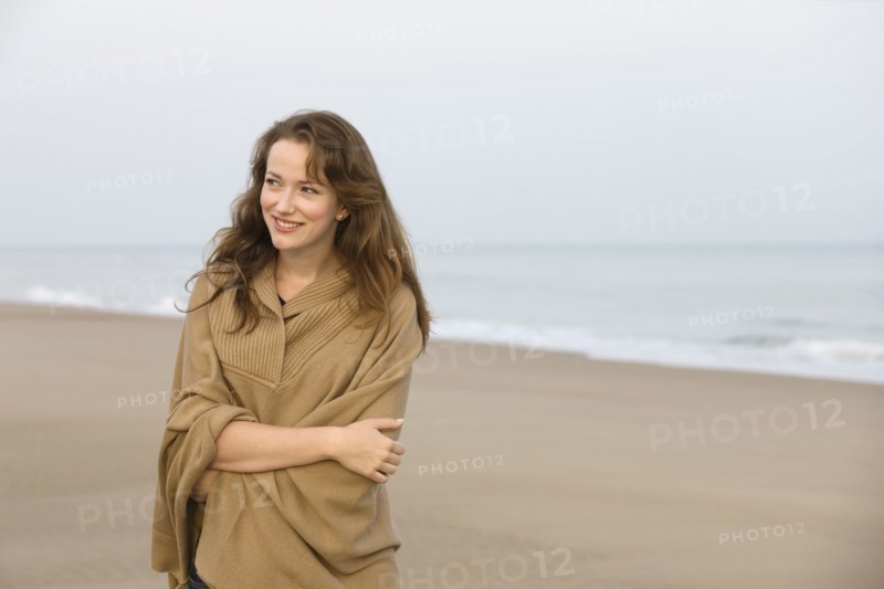 Young woman strolling on empty beach. 
Photo : Jan Scherders
