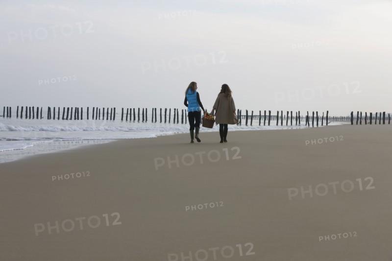 France, Pas-de-Calais, Escalles, Two women strolling on empty beach. 
Photo : Jan Scherders