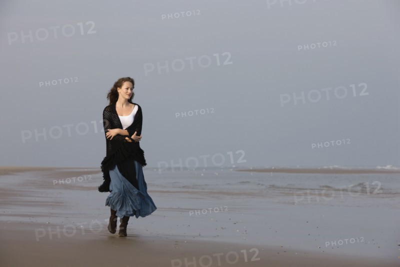 France, Pas-de-Calais, Escalles, Young woman strolling on empty beach. 
Photo : Jan Scherders