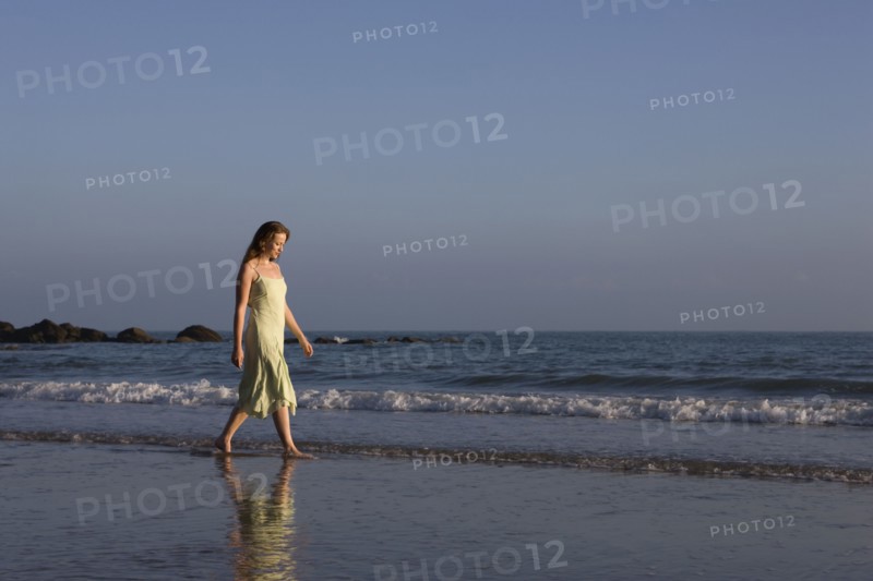 France, Pas-de-Calais, Escalles, Young woman strolling on empty beach. 
Photo : Jan Scherders