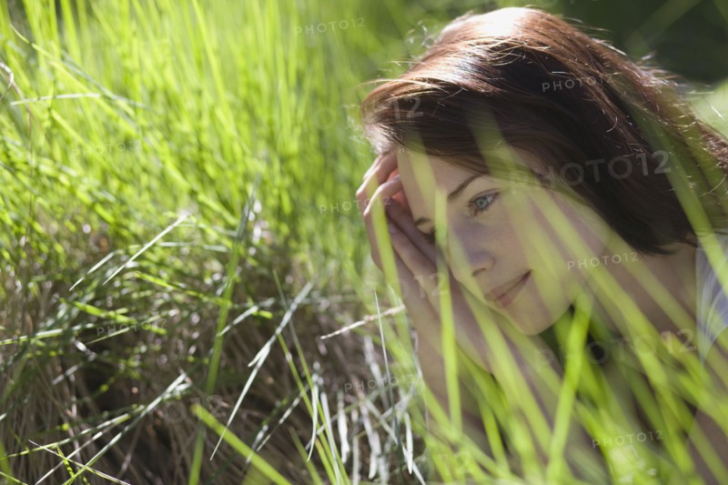 Young woman among green grass. 
Photo : Jan Scherders