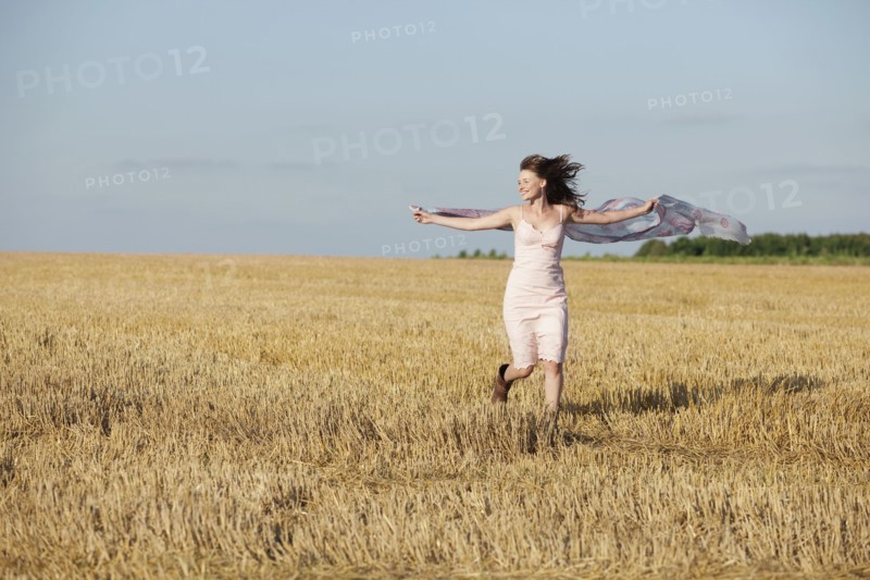 France, Picardie, Albert, Young woman running through stubble with shawl. 
Photo : Jan Scherders