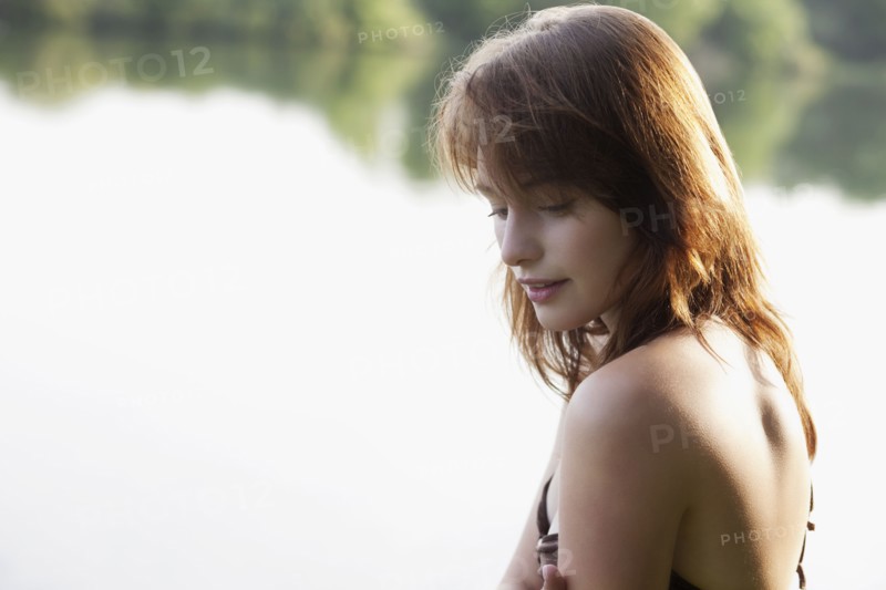 Portrait of young woman against lake. 
Photo : Jan Scherders