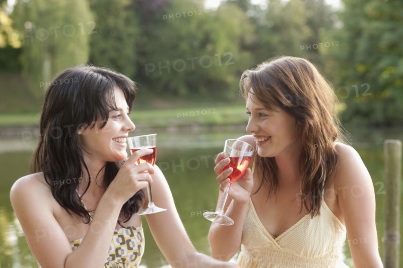 France, Picardie, Albert, Young women having picnic on lakeside. 
Photo : Jan Scherders