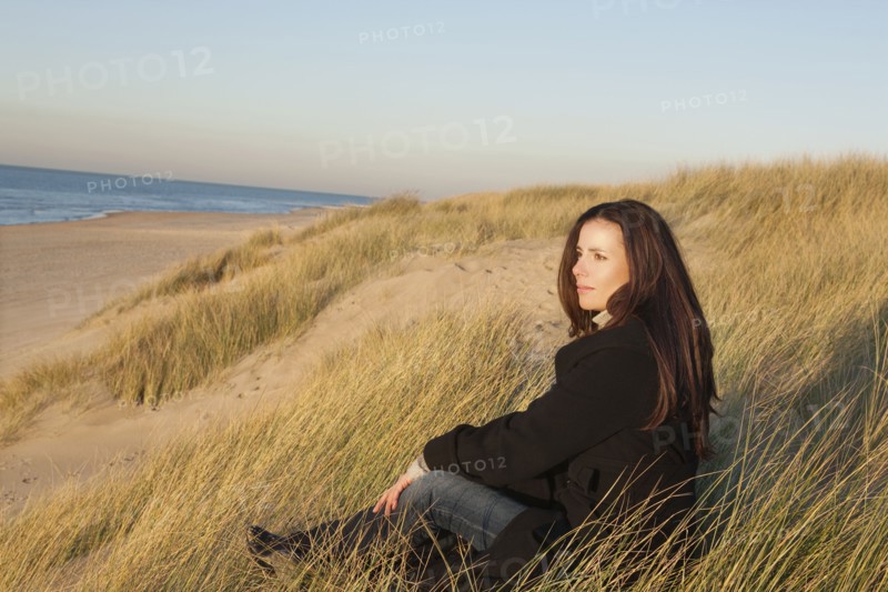 Netherlands, Zeeland, Haamstede, Woman relaxing on sand dune. 
Photo : Jan Scherders