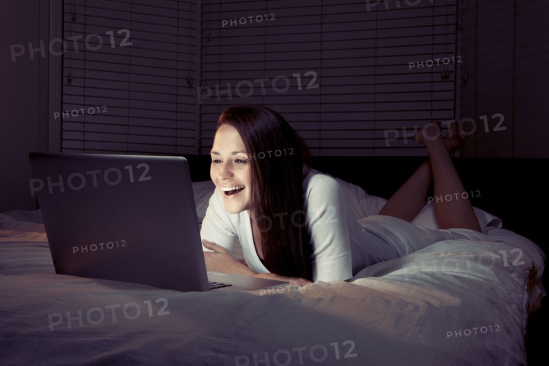 Woman using laptop in bed. 
Photo : King Lawrence