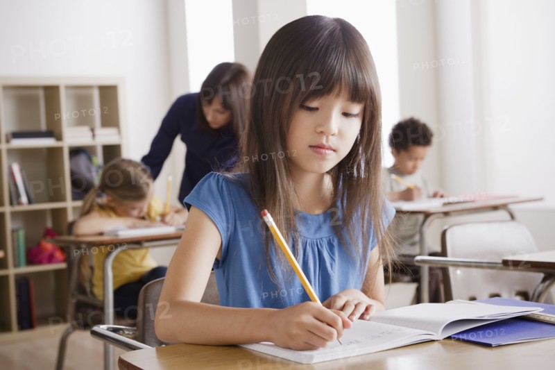 Schoolgirl focused on writing. 
Photo : Rob Lewine