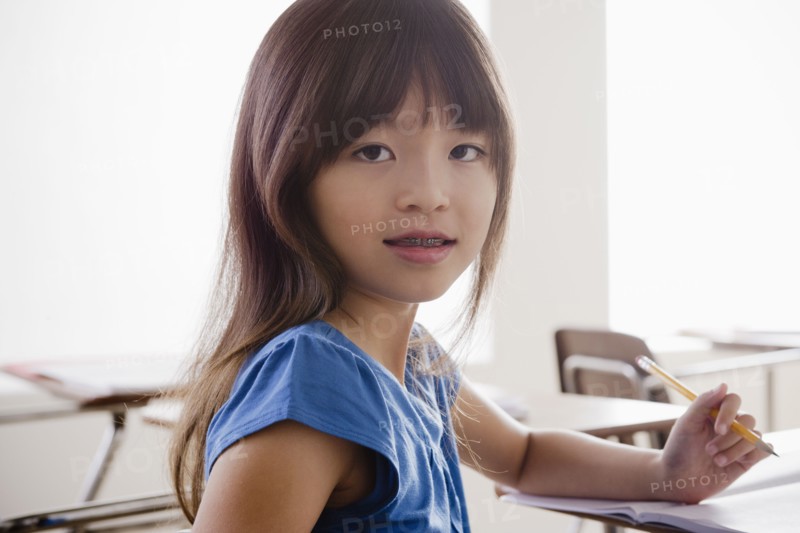 Portrait of schoolgirl holding pencil. 
Photo: Rob Lewine