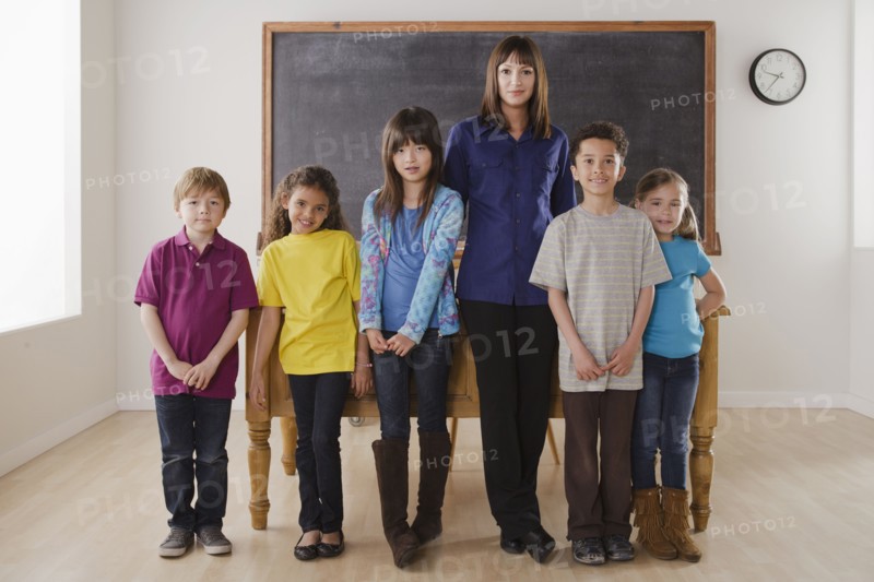 Teacher with group of pupils in front of blackboard. 
Photo: Rob Lewine